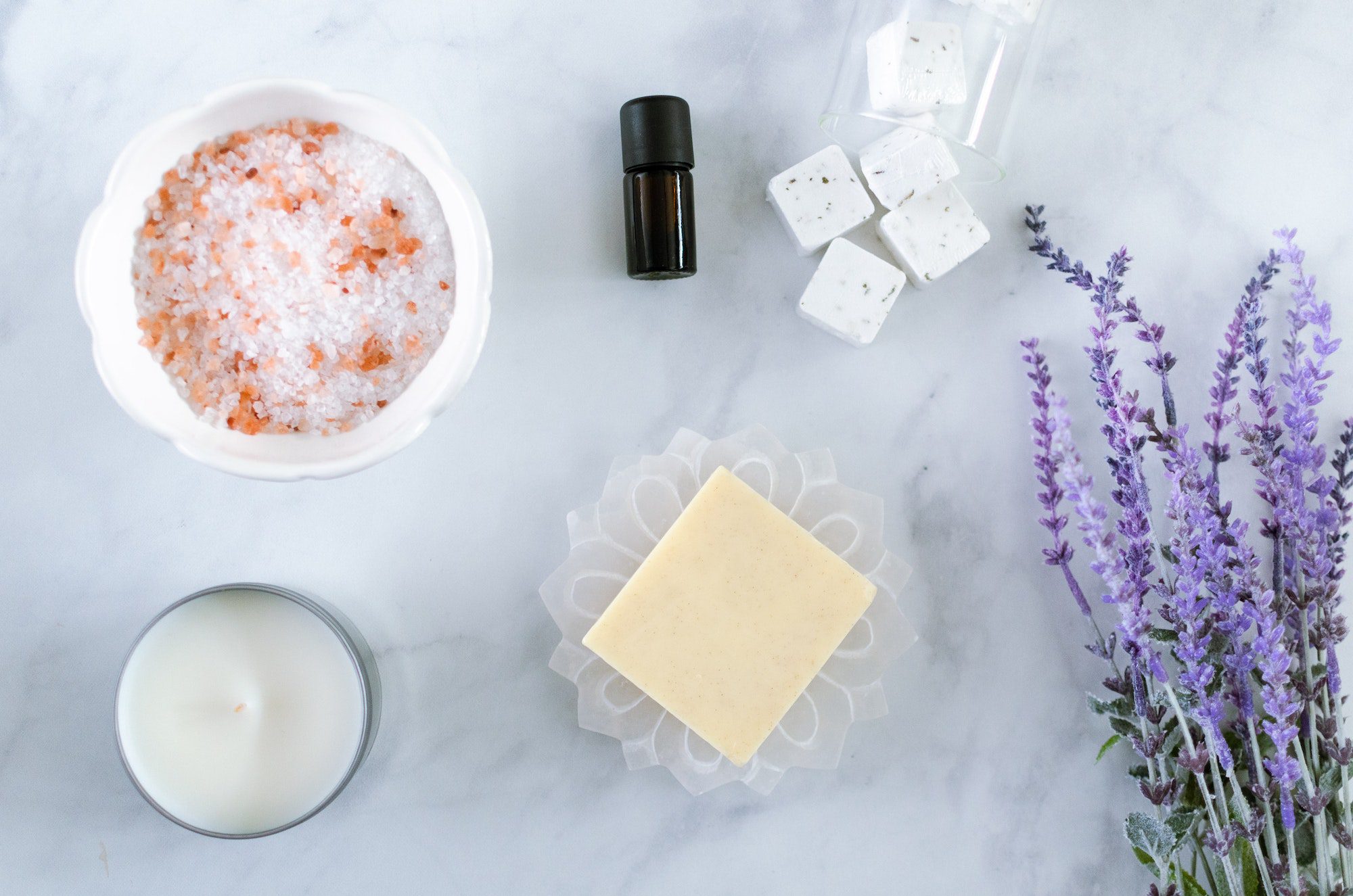 Self care spa day flat lay with candle, bath salts, essential oils, lavender